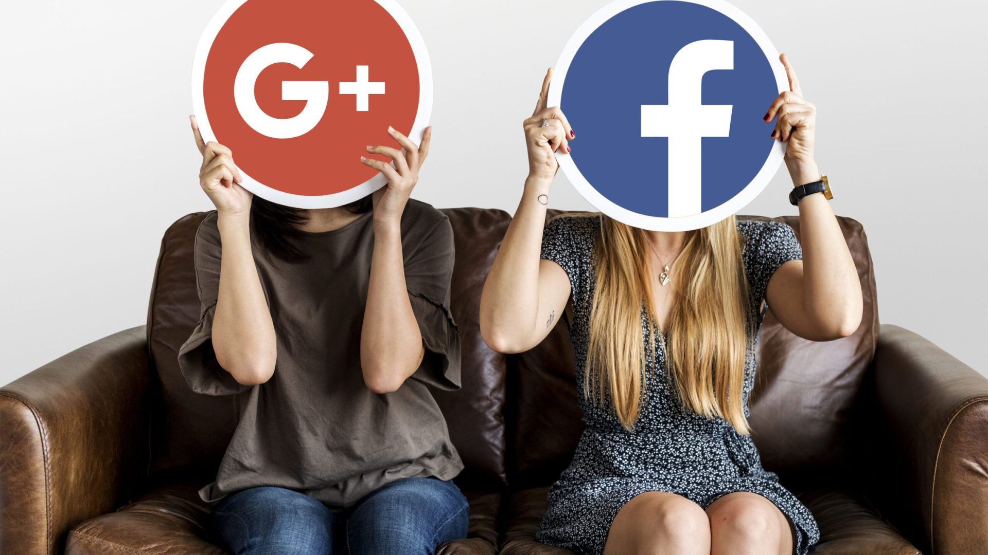 Interracial women holding an expressive emoticon face surprised Women holding social media icons
